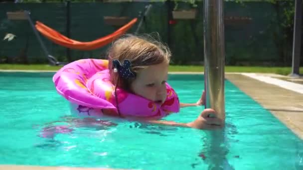 Klein meisje in drijven in het zwembad zwemmen — Stockvideo