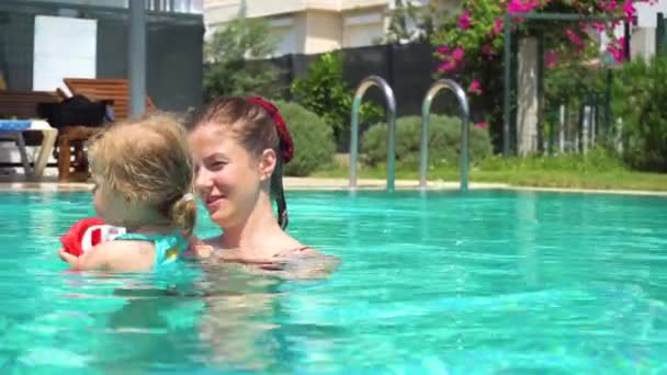 Mor och dotter som simmar i poolen i sommar — Stockvideo