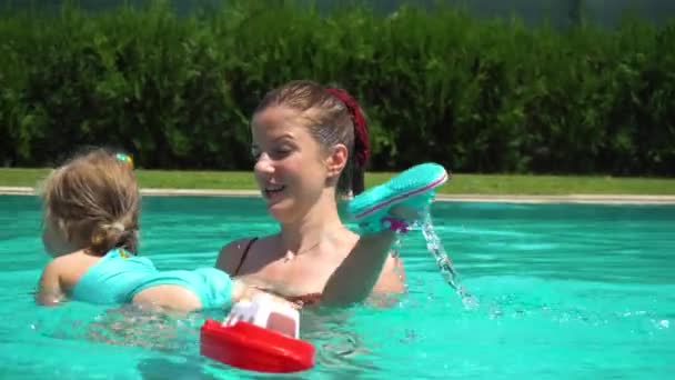 Moeder en dochter zwemmen in zwembad op vakantie — Stockvideo