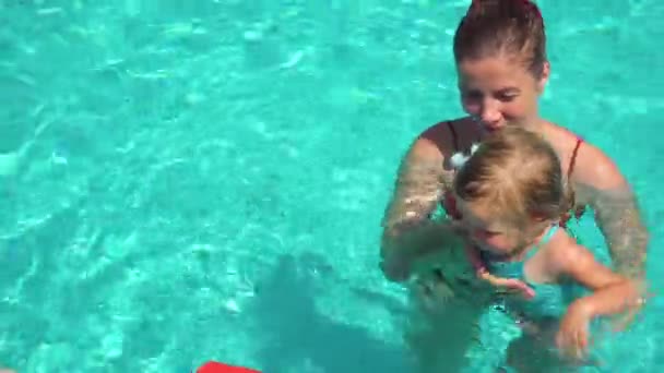 Chica aprendiendo a nadar con sus madres ayudan — Vídeo de stock
