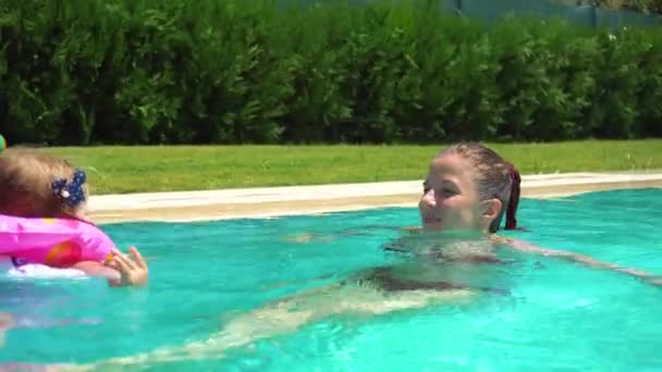 Woman and little girl having fun in swimming pool — Stock Video