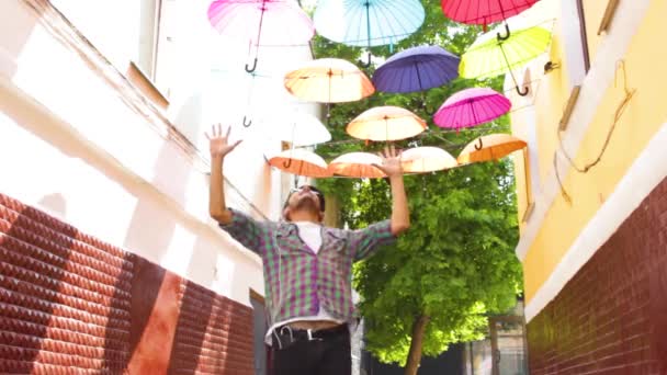Азиатский мужчина в наушниках танцует на открытом воздухе — стоковое видео