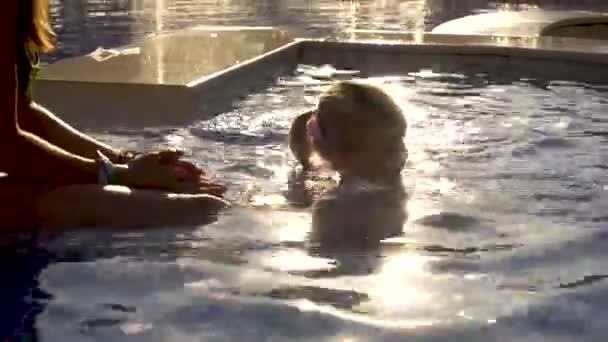 Mulher e menina brincando na piscina — Vídeo de Stock