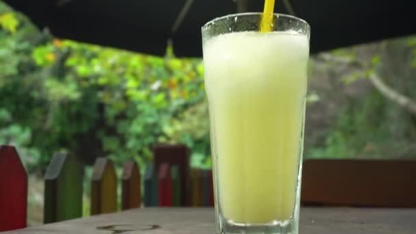 Mesa con bebida fría cerca de hermoso estanque — Vídeos de Stock