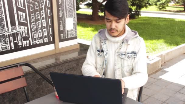 Uomo freelance sta lavorando in caffè sul computer portatile — Video Stock