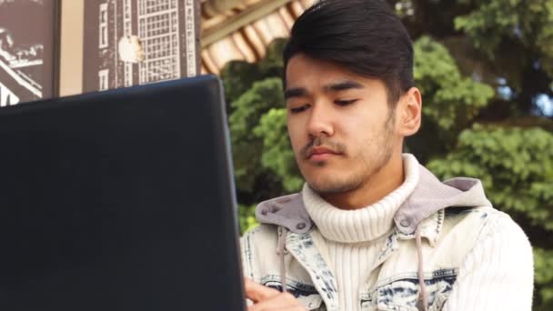 Hombre asiático freelancer trabajando en el ordenador portátil — Vídeo de stock