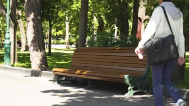 Parkta yürüyüş ve dinlenme için bankta oturuyor Asyalı adam