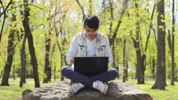 Trött man frilansare arbetar på laptop i parken — Stockvideo