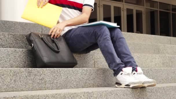 Homme étudiant avec des livres sur les escaliers — Video