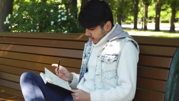 Hombre escribiendo un poco de texto en el cuaderno shedule — Vídeos de Stock