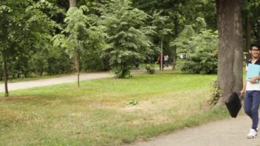 Yaz günü parkta yürüyen öğrenci Asyalı adam