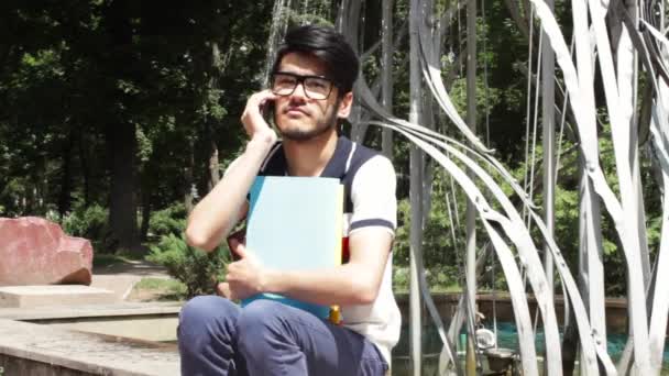 Estudiante con libros haciendo llamadas telefónicas — Vídeo de stock