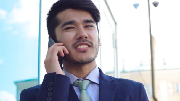 Портрет говорящего на смартфоне азиатского человека — стоковое видео