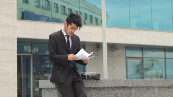 Homme lisant des journaux d'affaires à l'extérieur — Video