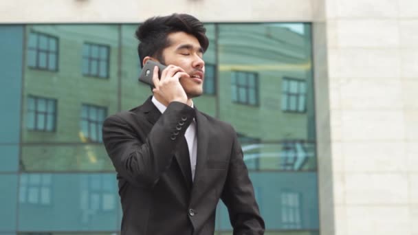 Hombre asiático en traje de negocios haciendo llamadas telefónicas — Vídeos de Stock