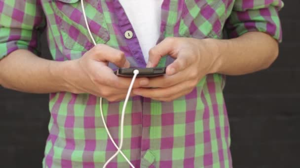 Человек ищет музыку в своем смартфоне — стоковое видео