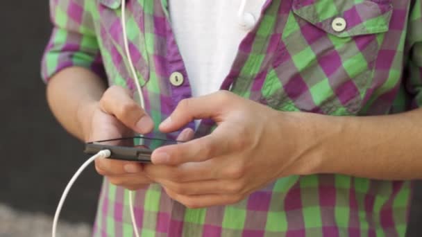 Man op zoek naar muziek op zijn smartphone — Stockvideo