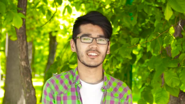 Азіатські Студентська людина дивиться в камеру і посміхається — стокове відео