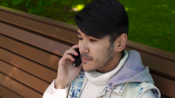 Sourire asiatique l'homme parler par téléphone — Video