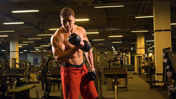 Bodybulder człowiek robi exerciese na jego biceps — Zdjęcie stockowe