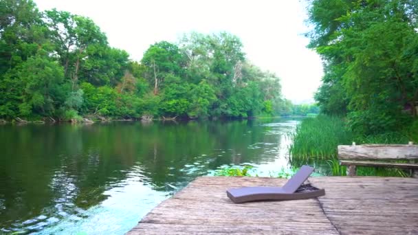 Ligstoelen op de houten pier op rivier — Stockvideo