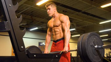 Halter tutarak ve egzersiz yaparak adam vücut geliştirmeci