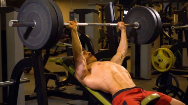 Adam göğüs egzersizleri yapıyor barbell ile