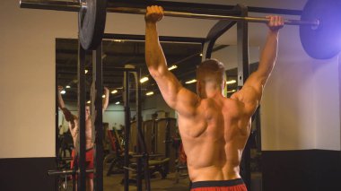 Spor salonunda barbell ile adam eğitimi