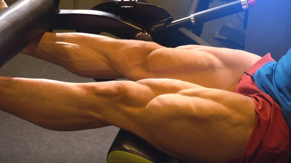 Vista ravvicinata delle gambe dell'uomo bodybuilder con muscoli tagliuzzati — Foto Stock