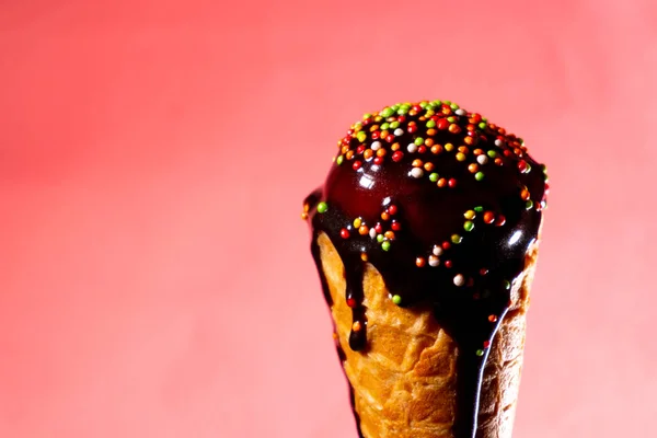 Ice cream with chocolate topping in waffle cone at pink background — Stock Photo, Image