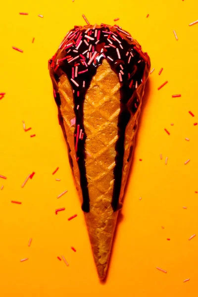 Delicioso sorvete com cobertura de chocolate no fundo amarelo — Fotografia de Stock