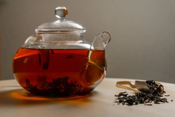 Černý vaří čaj v konvici na stůl — Stock fotografie