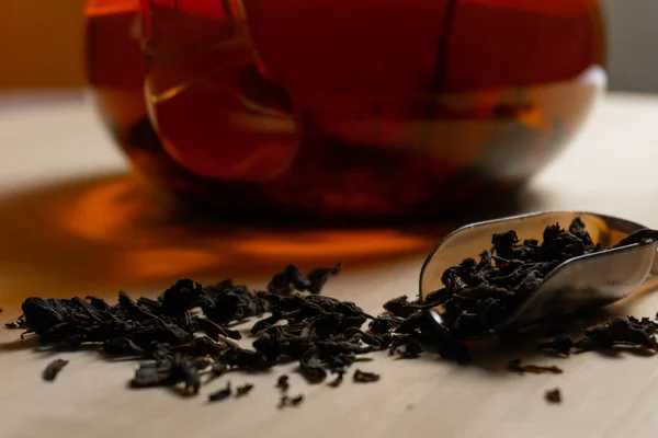Closeup black tea leafs on the table with tea spoon — Stock Photo, Image