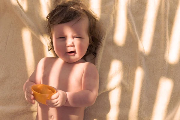 Carino bambino piccolo con tazza sulla coperta — Foto Stock
