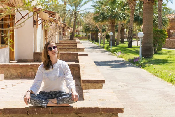 Pretty woman meditating on resort on vacation — Stock Photo, Image