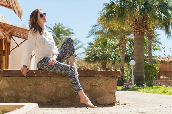 Pretty woman relaxing under sun on resort — Stock Photo, Image