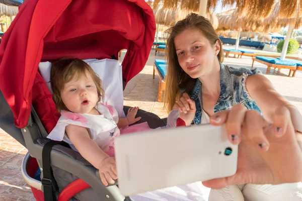 Mãe tomando selfie com bebê menina no resort — Fotografia de Stock