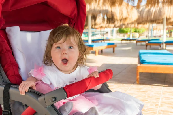 リゾートでの運送で面白い驚き赤ちゃん女の子 — ストック写真