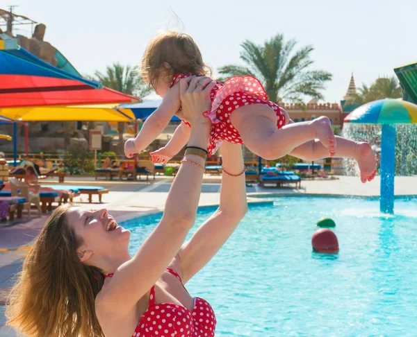 Moeder spelen met happy baby in waterpark — Stockfoto