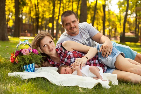 Schattig en gelukkige familie met newbork jong geitje in het park — Stockfoto