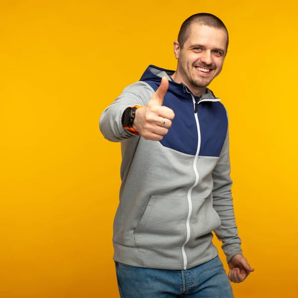 Homem feliz com capuz mostrar polegares para cima e sorrindo — Fotografia de Stock