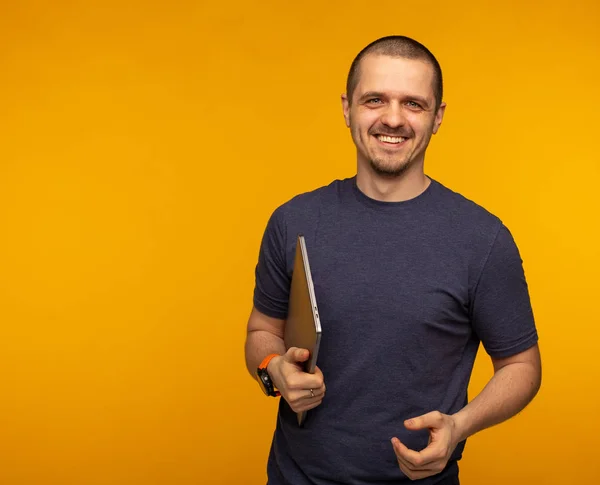 Чоловік-розробник або фрілансер тримає ноутбук і носить сіру футболку — стокове фото