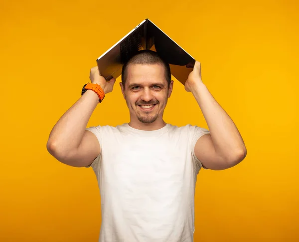 Чоловік фрілансер або ІТ-програміст тримає ноутбук над головою — стокове фото