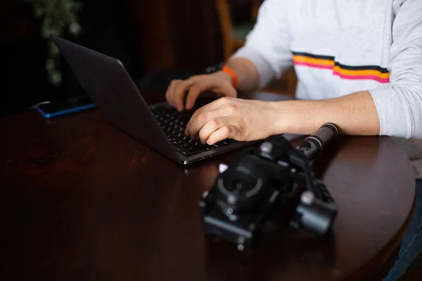 Ruce muže filmaře nebo blogger s notebookem a fotoaparát — Stock fotografie