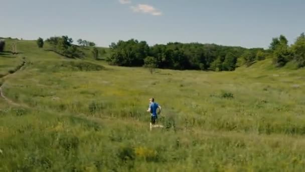 Man loper loopt buiten in het veld. Airial video van drone. — Stockvideo