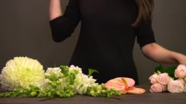 Çiçekçide çiçeklerle çalışan bir kadın.