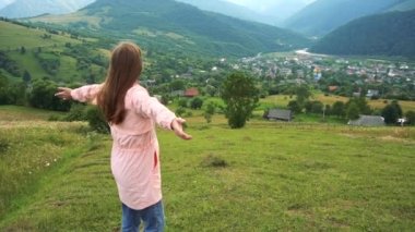 Dağ manzarasının tadını çıkaran mutlu kadın gezgin.