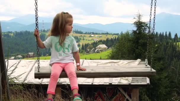 Menina balançando no balanço rural ao ar livre de madeira — Vídeo de Stock