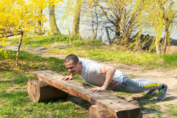 Dorosły mężczyzna robi pompki ćwiczenia outdoor — Zdjęcie stockowe