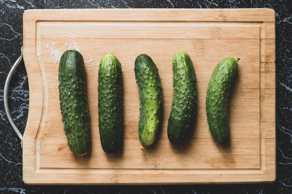 Five fresh ripe cucumbers on the wooden board — Stock Photo, Image